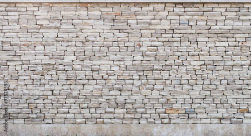 Photo Stone wall made of small limestone bricks