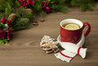 Czerwony kubek na drewnianym stole z herbatą, cytryną i z białym szalikiem