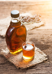 maple syrup in glass bottle on wooden table
