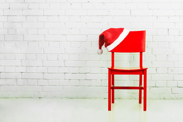 Wall Mural - Santa hat on a red wooden chair in a white room