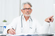 © Racle Fotodesign - älterer arzt zeigt auf bildschirm