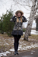 Happy young blonde woman on the background of a winter park