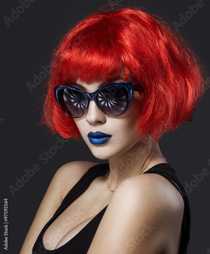 Naklejka na meble Beautiful girl in an blond wig cosplay style and in classic glasses with bright creative lips. Art beauty image. Portrait shot in the studio.