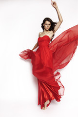 Wall Mural - Brunette model in red dress posing
