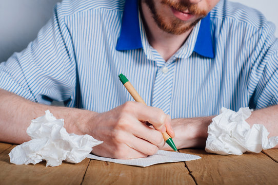 Young man writing on napkin