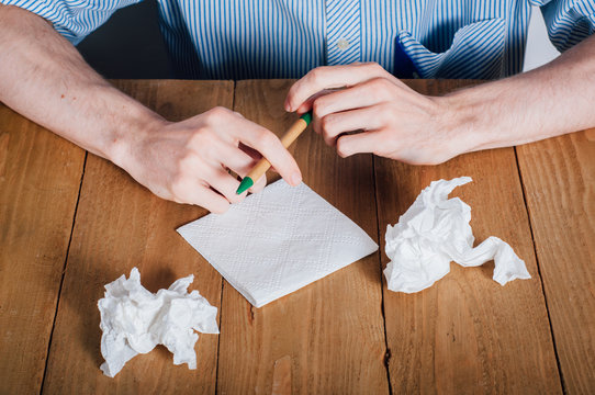 Young man writing on napkin