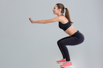 Wall Mural - Attractive young sportswoman doing squats