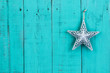 Silver tin star hanging on rustic wood background