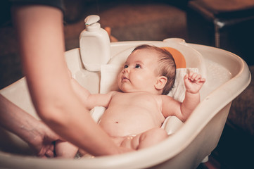 small baby first bathing on mothers hands