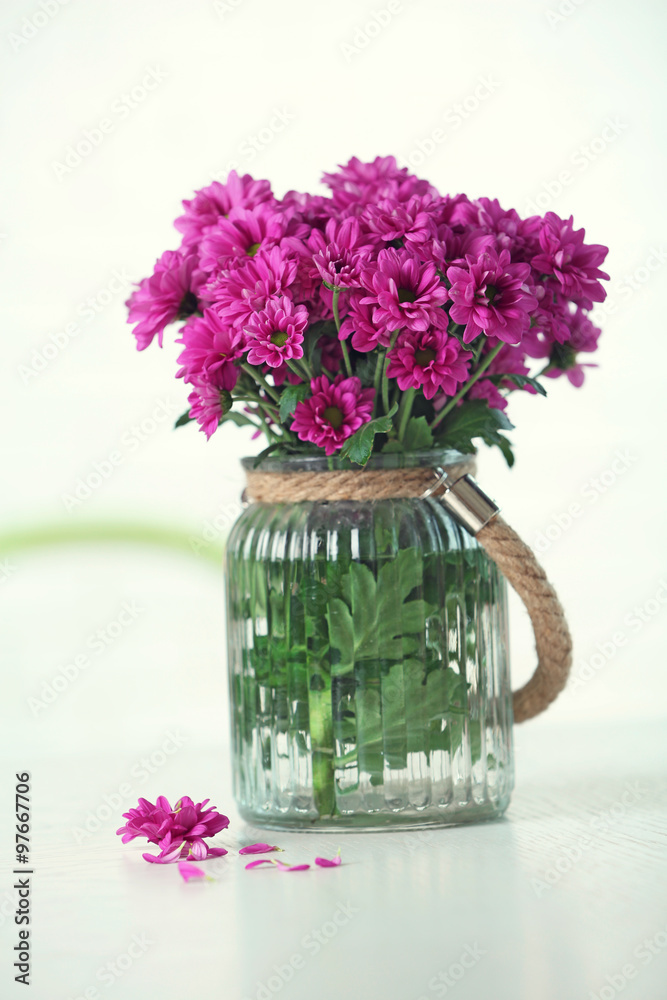 Beautiful flowers in vase on table in room