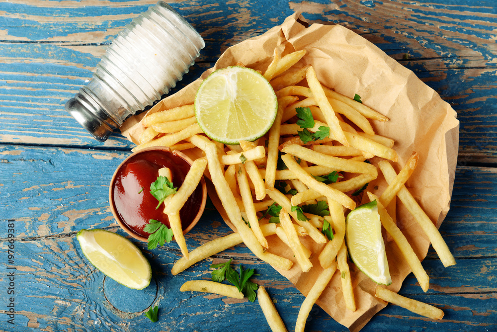 French fried potatoes on craft paper on cutting board