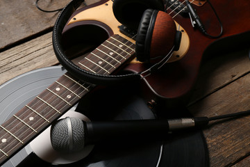 Wall Mural - Electric guitar and headphones with microphone and vinyl on wooden background