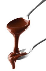 Wall Mural - Melted milk chocolate pouring from spoons, isolated on white