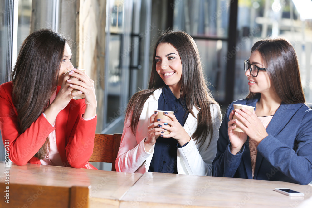 Attractive stylish girls pose with cup of coffee