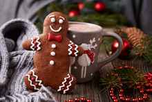 Hot Chocolate Or Cocoa Beverage In Cup With Cute Deer, Cinnamon And Gingerbread Man Cookie Inside New Year Tree Decorations Frame On Vintage Wooden Table Background. Homemade Dessert Recipe.