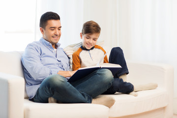 Wall Mural - happy father and son reading book at home