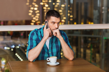 man with smartphone and coffee at restaurant