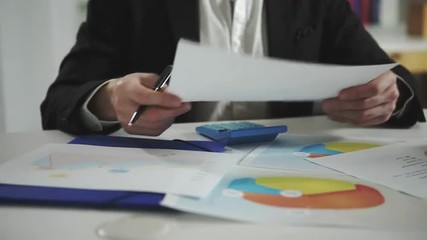 Poster - a man looks at the charts and checks them using a calculator