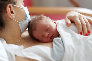 one day old newborn baby with mother
