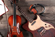 © Africa Studio - Electric guitar, violin, soprano saxophone, headphones and book on wooden background