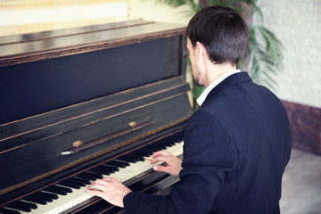 Poster - Handsome man in black suit plays piano in the class