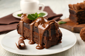 Wall Mural - A piece of chocolate cake with mint on the table, close-up