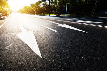 sunlight and empty asphalt road with traffic sign