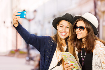 Two cute girls taking selfies with mobile phone