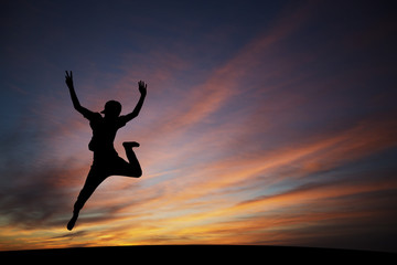 Wall Mural - silhouetted boy jumping in sunset for fun