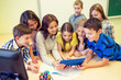© Syda Productions - group of kids with teacher and tablet pc at school