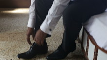 Man In White Wedding Shirt Puts On Black Shoes Ties Shoe-laces