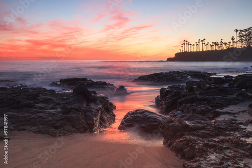Fotografía Long exposure of rocks and seaweed moss in waves, giving a mist like effect over