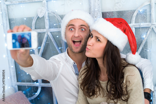 Fotografia, Obraz Christmas selfie.Young beautiful couple in love is making selfie