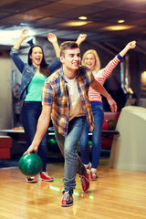 Canvas Print - happy young man throwing ball in bowling club