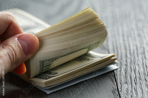 Fotomural man hands counting dollar notes on wood table