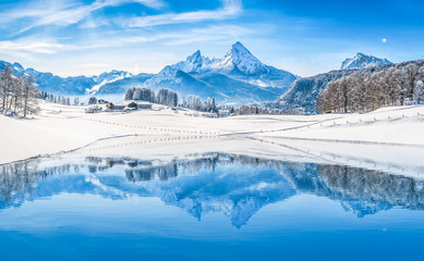 Winter wonderland in the Alps reflecting in crystal clear mountain lake