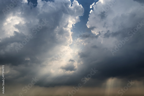 Naklejka na drzwi Light shines through storm clouds before a storm is coming.