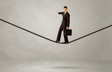 Salesman walking on rope in grey space