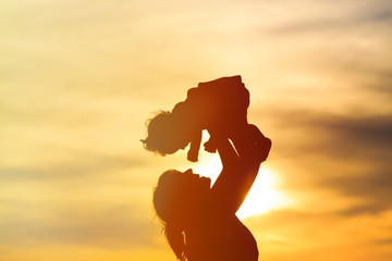 Wall Mural - mother and little daughter play at sunset