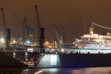 Wall Mural - hamburg harbor cranes with ship in construction germany at night