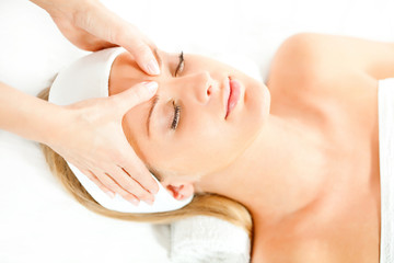 Young woman having forehead massage on spa treatment