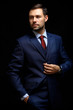 © opolja - Handsome young business man standing on black background