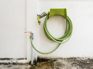 Green rubber tube and water hose joined with faucet and rolled o