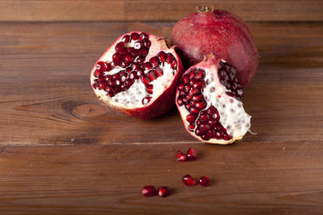 two ripe pomegranate on a wooden rustic background