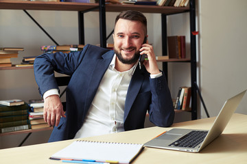 Wall Mural - businessman looking at camera and talking on the phone