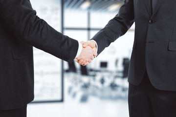 Wall Mural - business partners shake hands in modern conference room