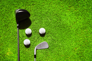 Wall Mural - Golf clubs and ball on a green grass