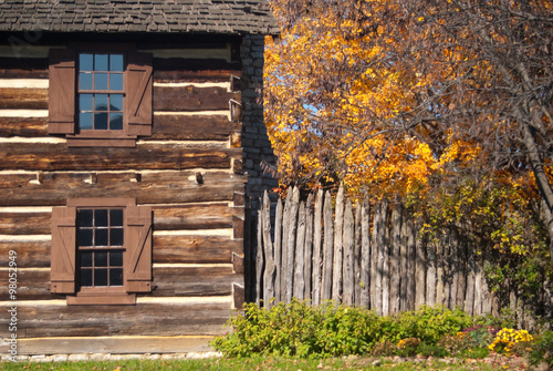 Rustic Fall Setting Of Old Log Cabin With Pumpkins Gourds Indian
