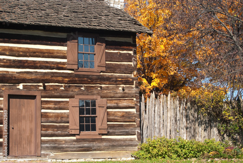 Rustic Fall Setting Of Old Log Cabin With Pumpkins Gourds Indian
