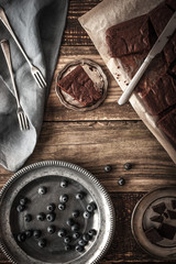 Wall Mural - Slices of chocolate brownie with blueberry and vintage dinnerware  vertical